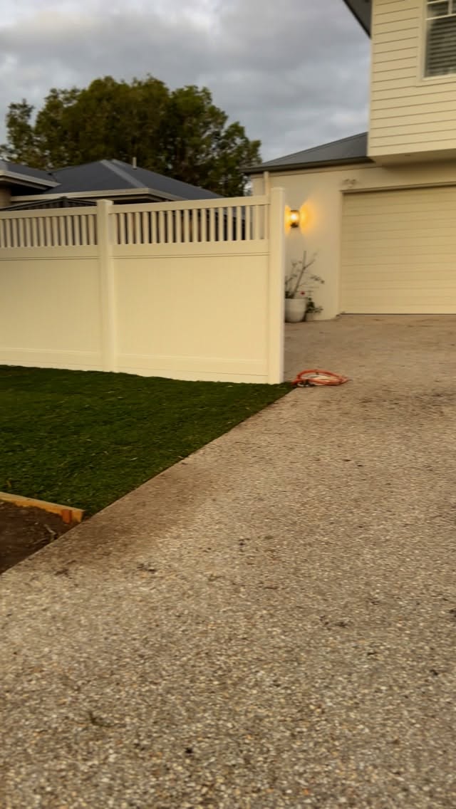 New turf laid in a narrow side yard beside the driveway